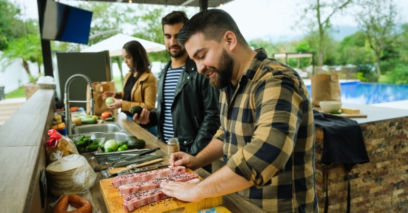 חברים מבשלים יחד במטבח החיצוני